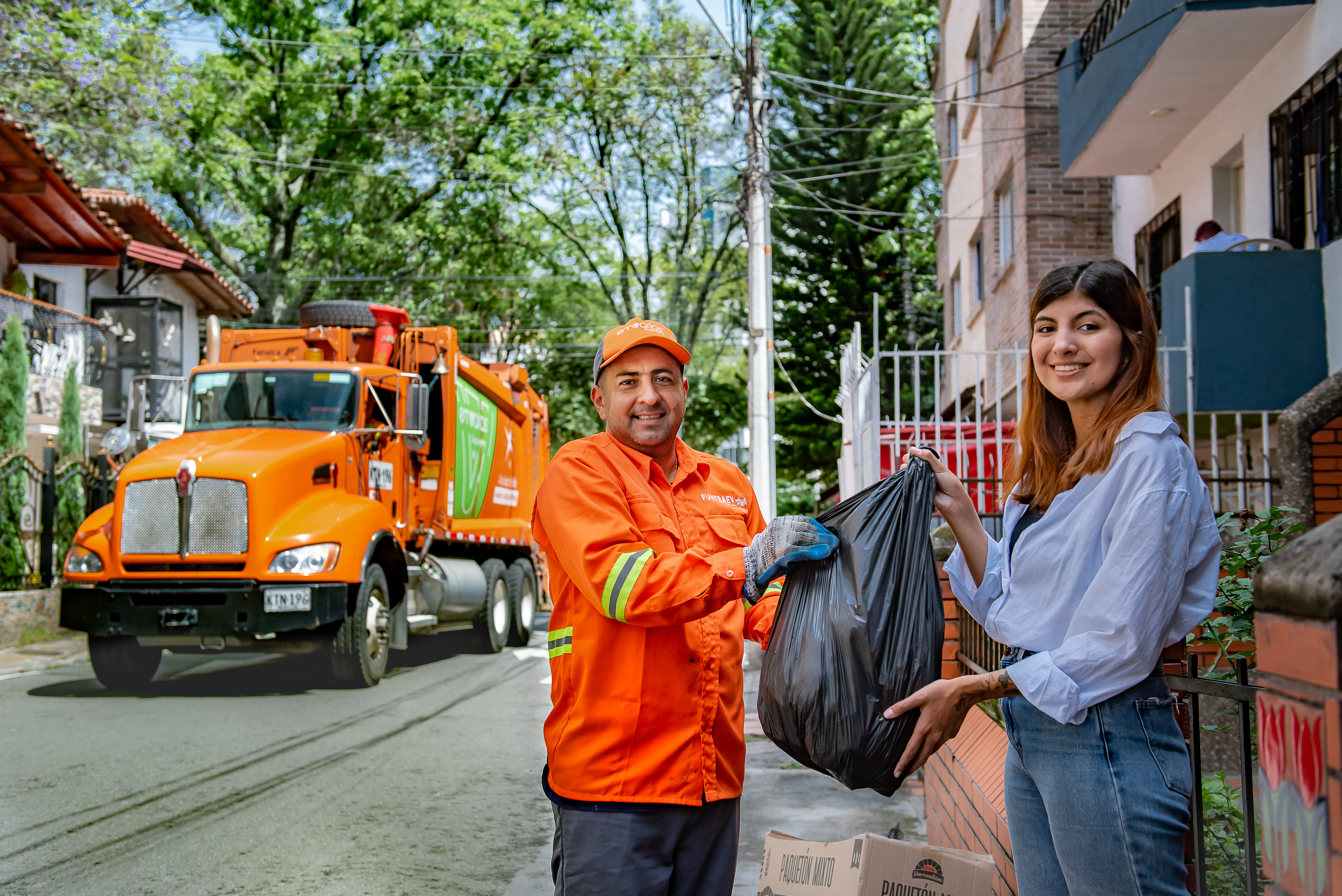 Persona depositando residuos en contenedor verde de Emvarias
